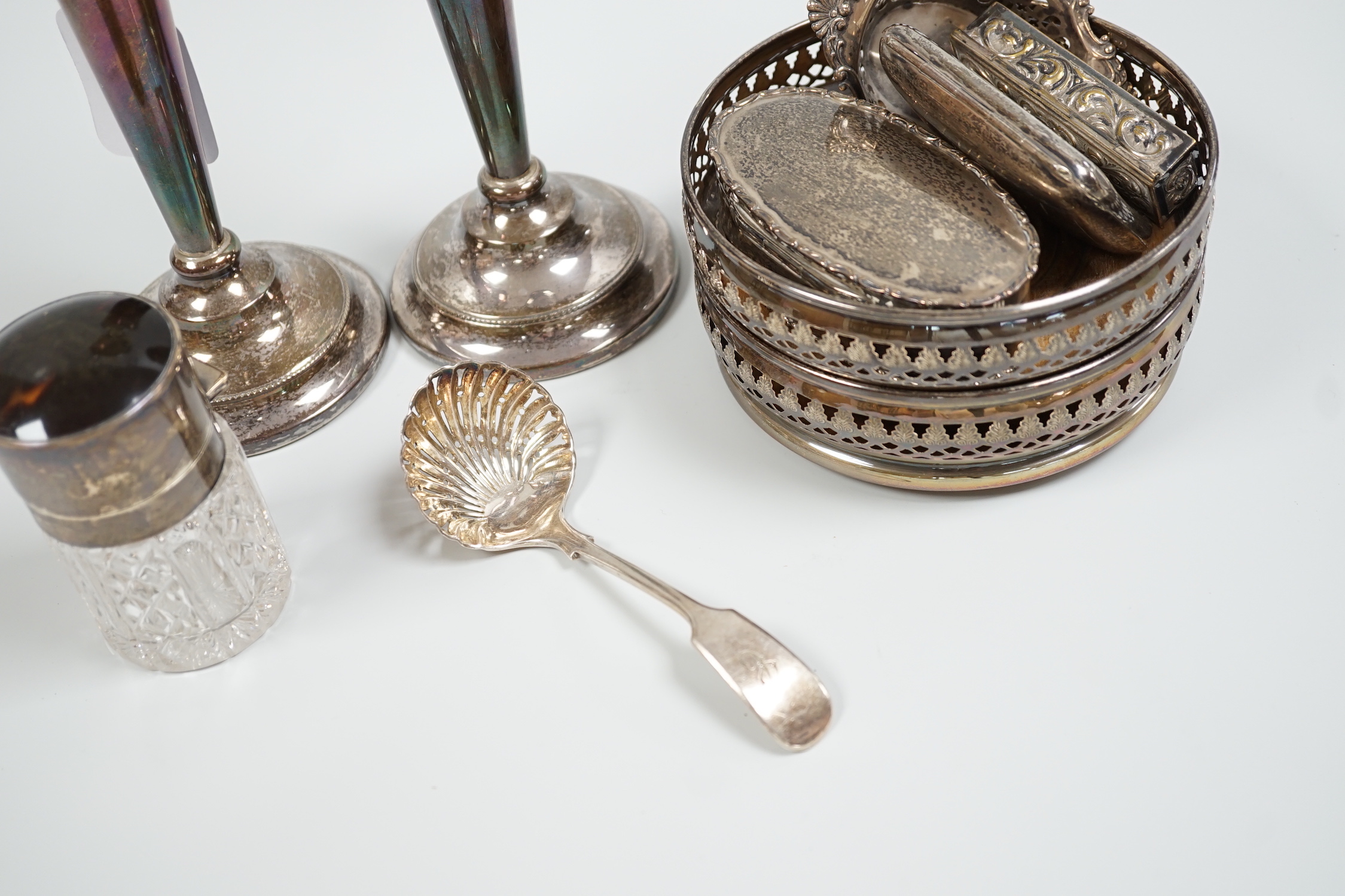 A pair of 1960's pierced silver wine coasters, London, 1968, diameter 13.2cm, a modern pair of silver candlesticks, a silver and tortoiseshell mounted glass salts bottle, a silver trinket box, sterling pierced dish, silv